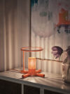 Fireplace Lamp by HYBE DESIGN TEAM features mouth-blown glass hovering above a crossed log base with warm, flickering LED illumination.
